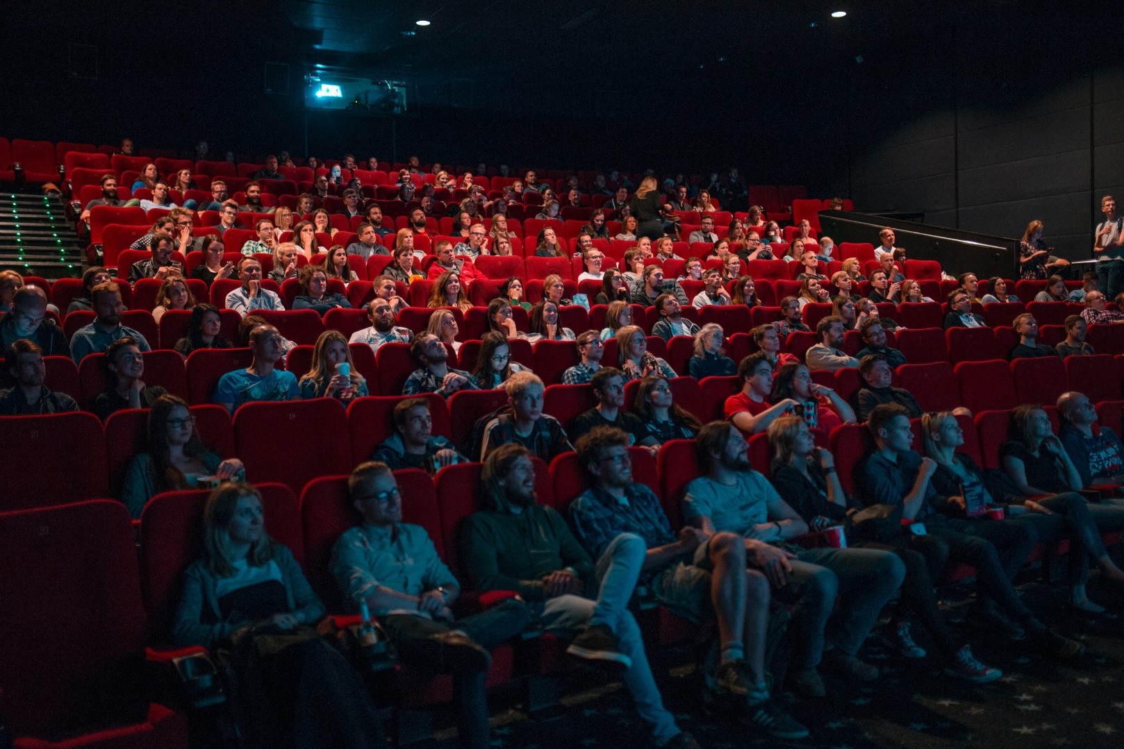 Sala de cine casi llena con butacas rojas